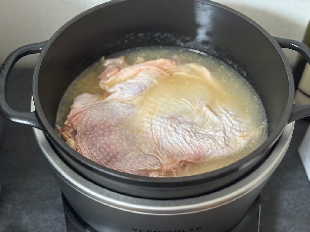 鶏肉とお米を炊飯鍋に入れてカオマンガイを炊く準備をしている様子