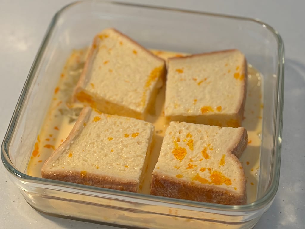 卵液に食パンをじっくり浸している様子