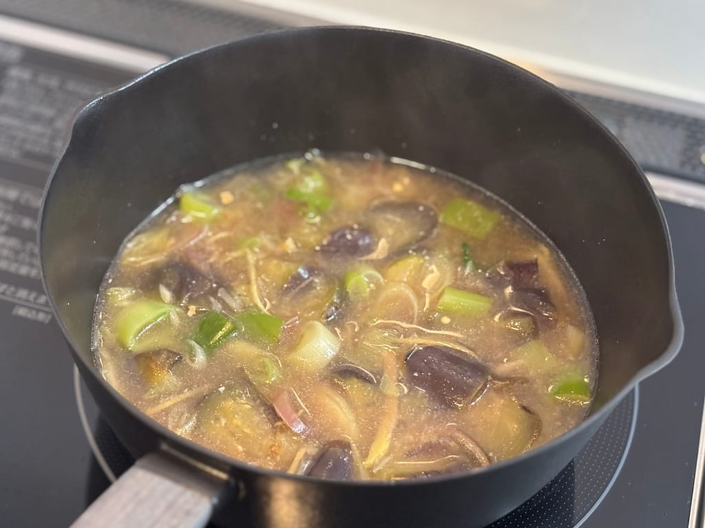 なすと長ねぎを炒め、だし汁で煮込んで味噌汁を仕上げるまでの手順を写した工程写真。