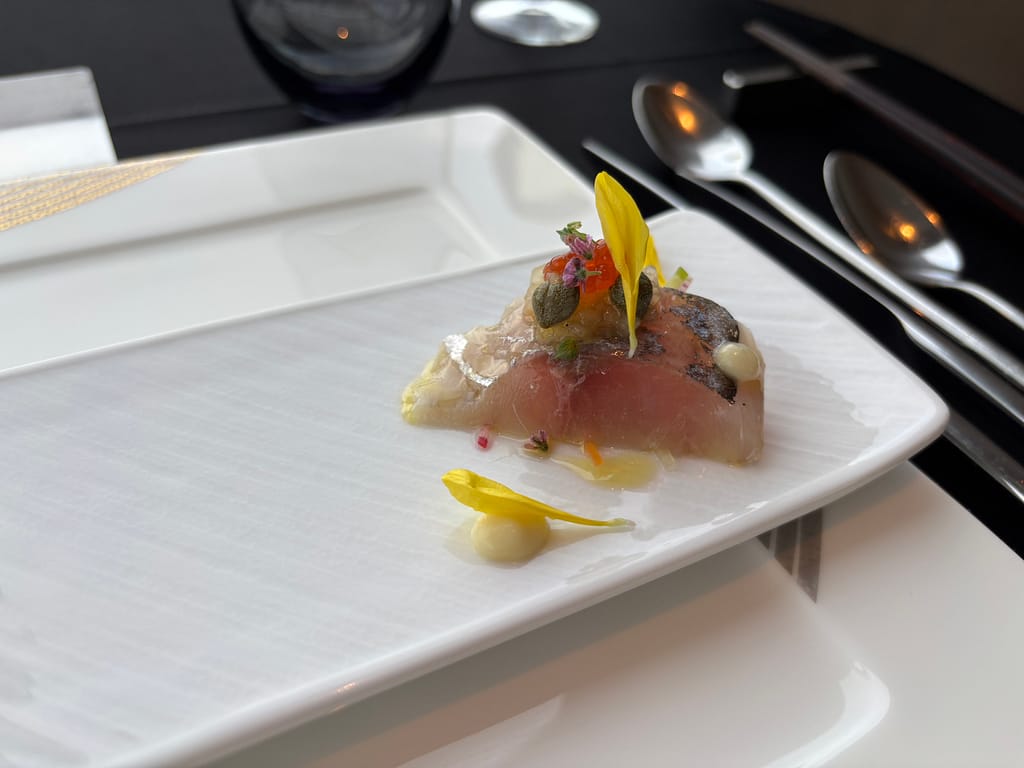 アミューズ・真鯵の柑橘ジュレ「TENQOOのアミューズ、真鯵の柑橘ジュレがけ。キャビアやエディブルフラワーを添えた華やかな一皿。」