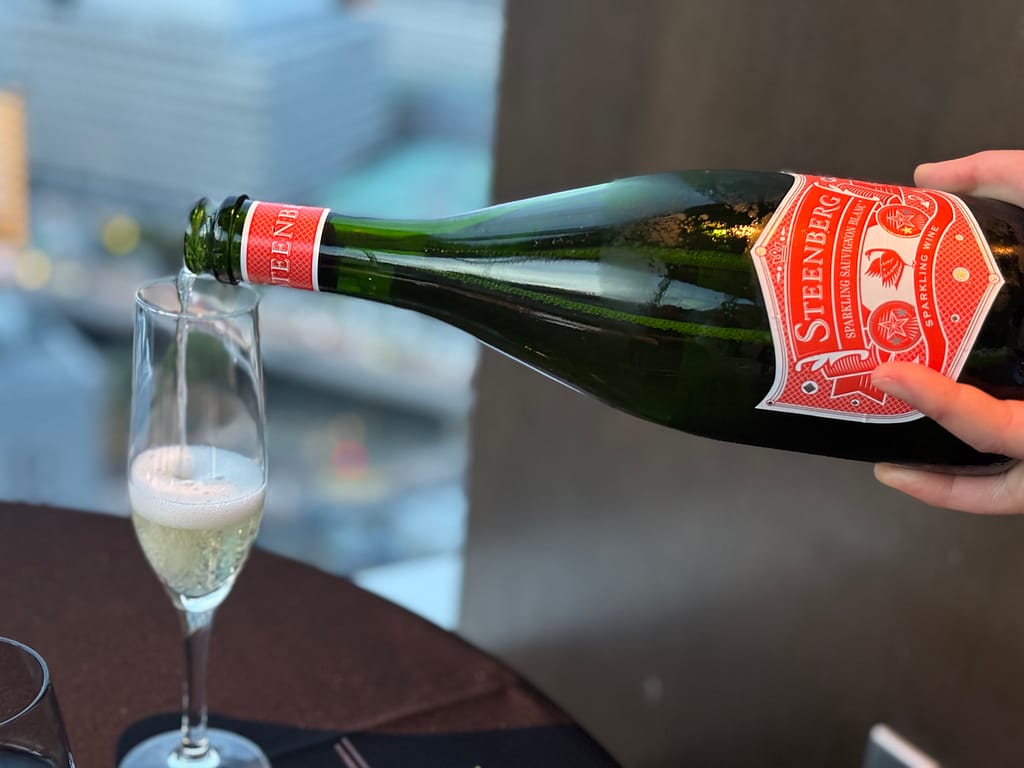 スパークリングワイン「TENQOOでスパークリングワインをグラスに注ぐ様子。STEENBERGのボトルを使用。」