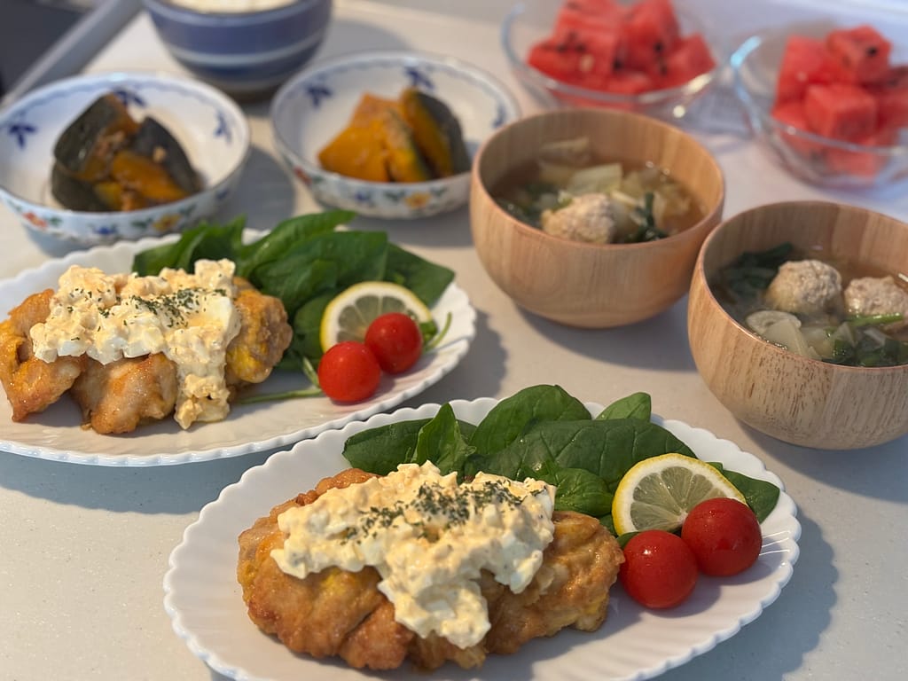 盛り付け写真③タルタルソースをたっぷりかけたチキン南蛮と、汁物、副菜、デザートが写った写真。彩りが良い食卓。