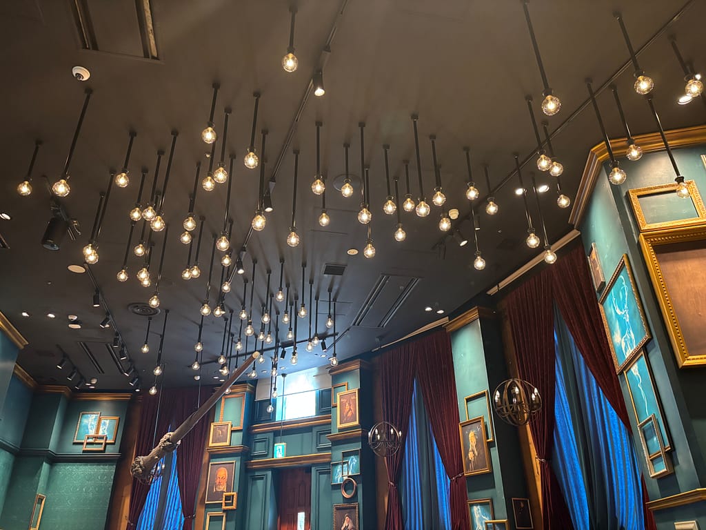 赤坂ハリーポッターカフェの店内、天井に無数の電球が輝き、魔法の杖が宙に浮かぶように展示された幻想的な雰囲気