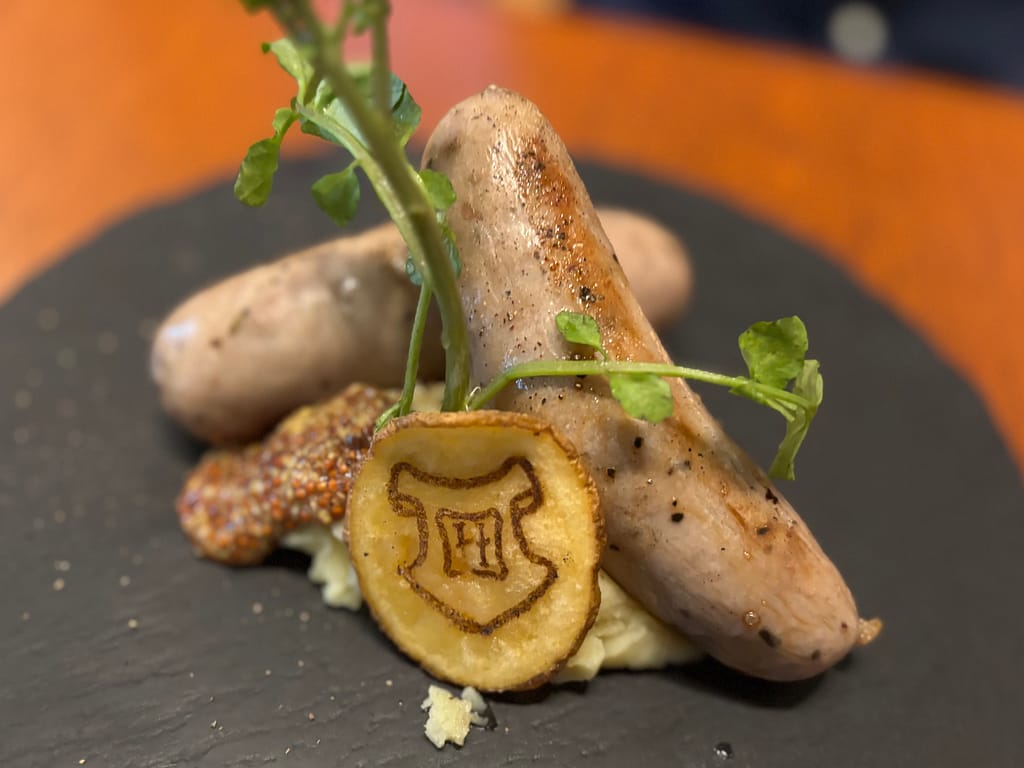 ハリーポッターカフェのホグワーツソーセージ＆マッシュポテト、盾マーク入りポテトと粒マスタード添え