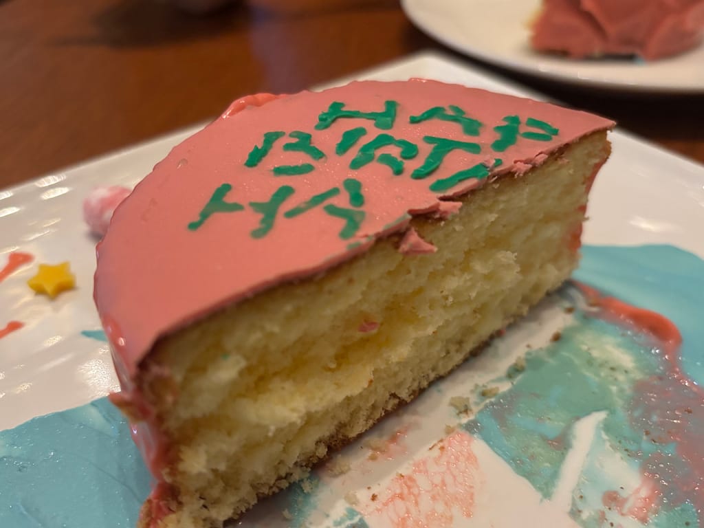 カットされたハリーポッターカフェのバースデーケーキ、ふわふわスポンジにピンクのアイシング