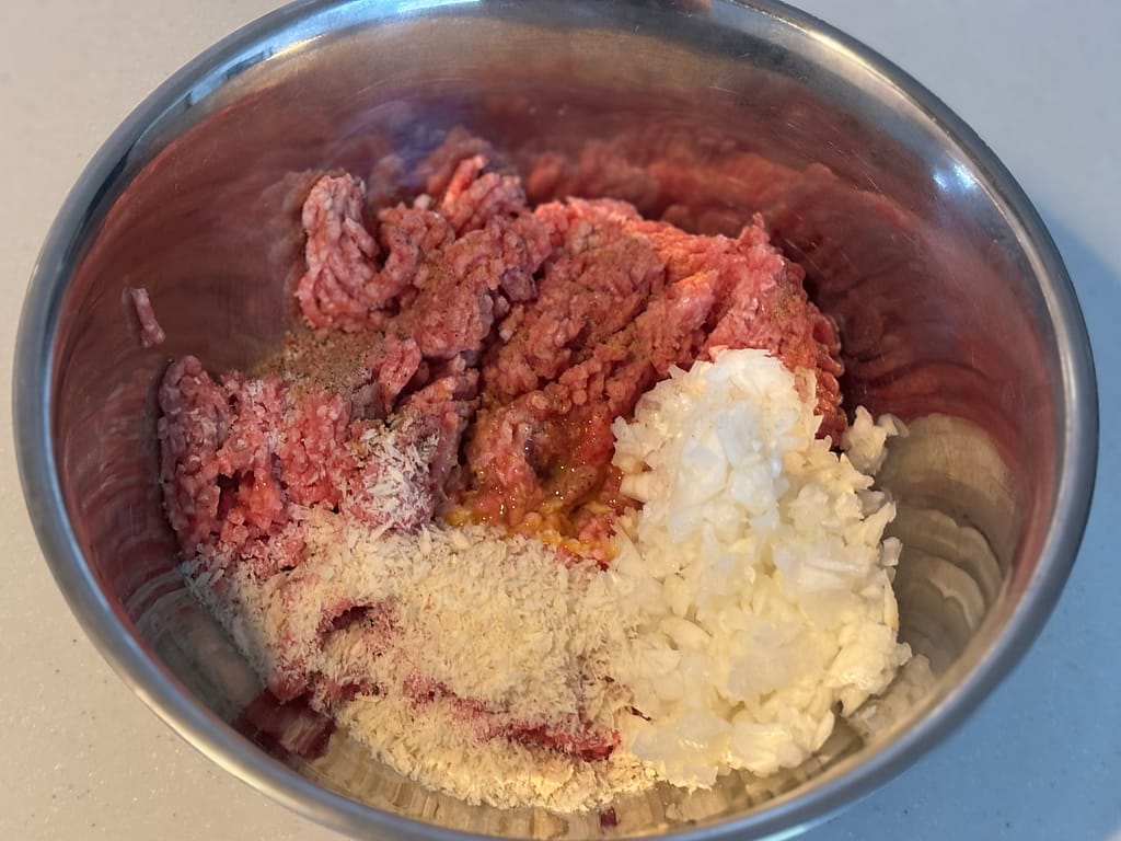 ひき肉のタネ準備
「ボウルに入った合いびき肉、刻み玉ねぎ、パン粉、卵などを混ぜ合わせる前のスコッチエッグ用タネ」