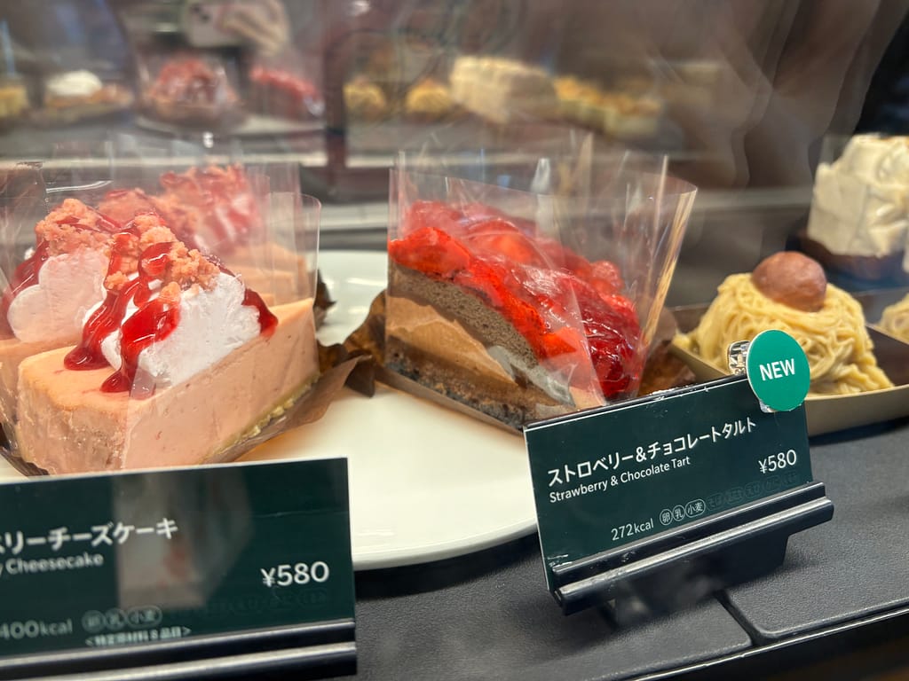 スターバックスのショーケースに並ぶストロベリー＆チョコレートタルト。鮮やかな赤いストロベリーが印象的な写真。