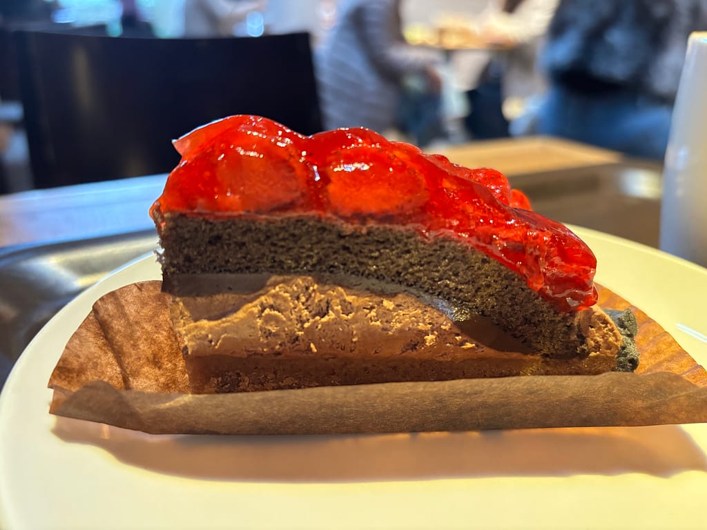 ストロベリー＆チョコレートタルトの断面。チョコレートムースと生地の層に、ストロベリーソースが重なる。