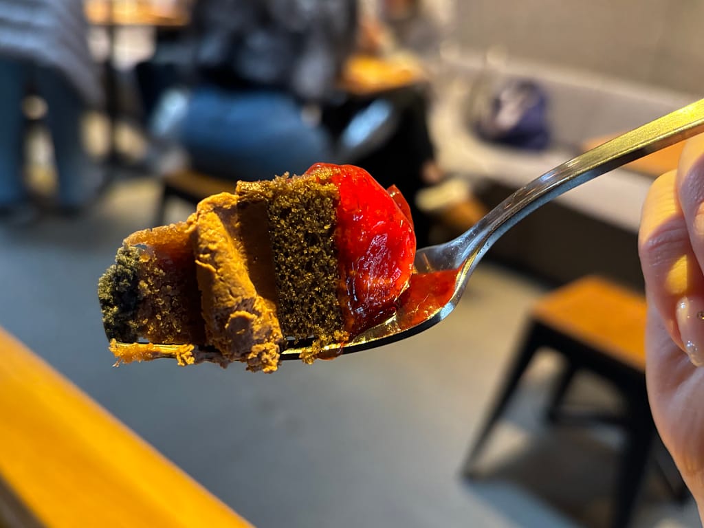 ストロベリー＆チョコレートタルトをスプーンですくった一口の写真。スプーンですくったストロベリー＆チョコレートタルト。チョコレート生地とストロベリーの層が分かる一口サイズ。