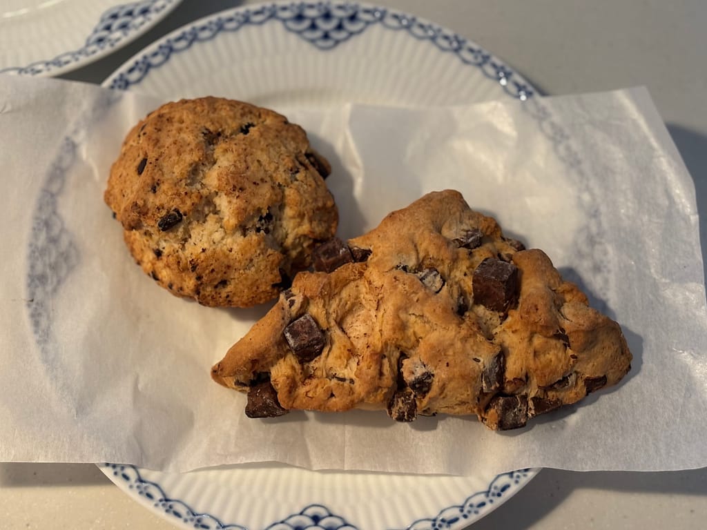 紙の上に並べたチョコレートチャンクスコーン2種類のサイズ比較